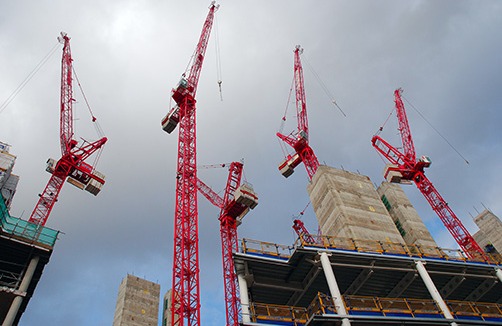 ground view looking at construction cranes