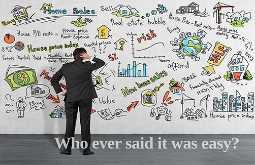 Image of a man looking confused in front of a whiteboard